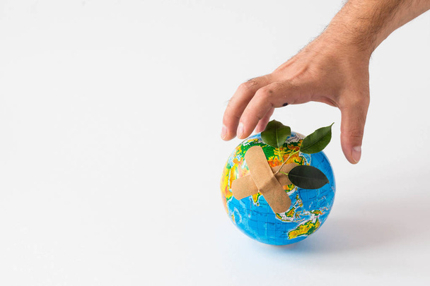Man hand holding object Earth isolated on white background. Save Earth concept. Ecology. Green planet. danger to the planet in the hands - Photo, Image