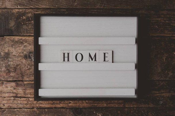 Üzerinde ahşap kahverengi bir arka plan üzerinde "Ev" yazan beyaz bir tabela - Fotoğraf, Görsel
