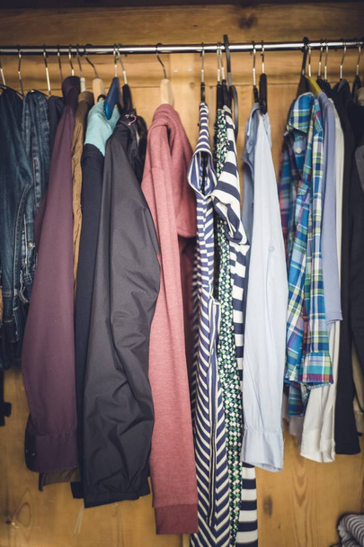 A vertical shot of various clothes hanging in the wardrobe - Foto, Bild