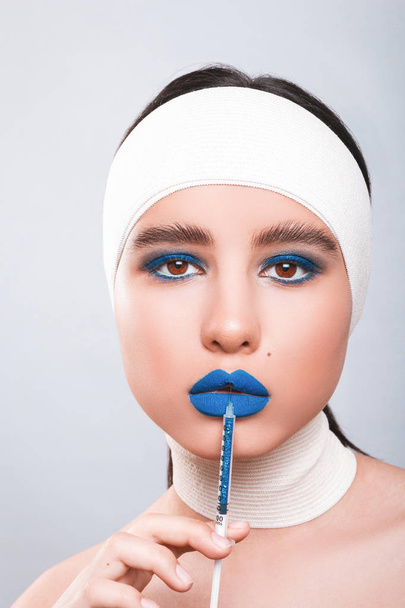 Beauty concept. Young model with blue lips and soft skin doing p - Фото, зображення