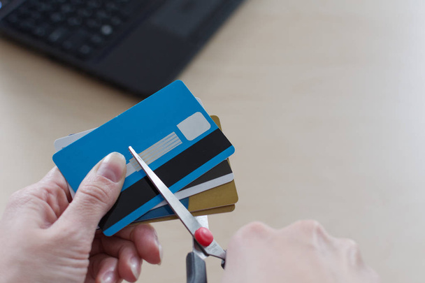 Cortar una tarjeta de crédito con una tijera
. - Foto, imagen