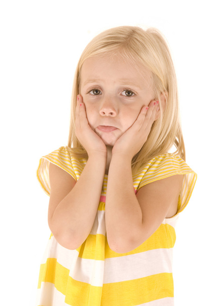 Chica rubia joven con la parte superior amarilla rayada con las manos en la cara triste
 - Foto, Imagen