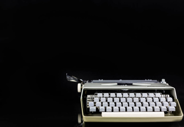 Máquina de escribir Vintage sobre la mesa sobre fondo negro con papel blanco y espacio vacío. Lugar de trabajo del escritor o autor. Concepto de Idea
. - Foto, Imagen