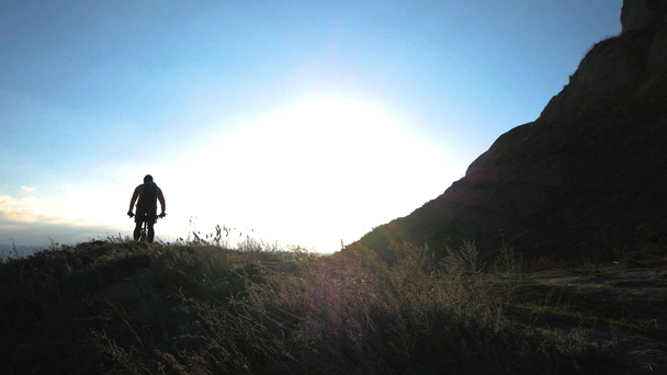 Genç erkek bisiklet binici yaz güneşli bir günde tepelerde seyahat - Video, Çekim
