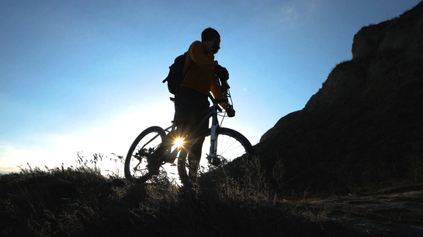 Genç erkek bisiklet binici yaz güneşli bir günde tepelerde seyahat - Video, Çekim
