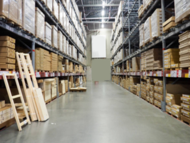 Blurred image of shelf in modern distribution warehouse or storehouse. Defocused background of industrial warehouse interior aisle - Photo, Image