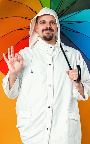 Mann im Regenmantel und mit Regenschirm - Foto, Bild