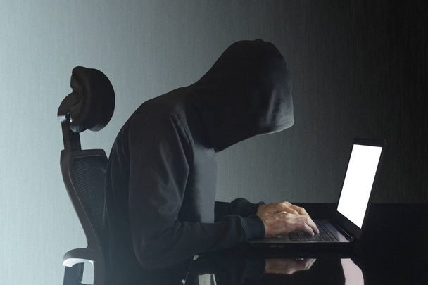 haker siedzi przy biurku z przycinającą ścieżką dookoła obiektu i kopiowaniem miejsca na tekst - Zdjęcie, obraz