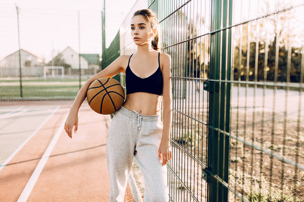 young athletic girl, outdoors, posing with a basketball. Sport,  - Fotoğraf, Görsel