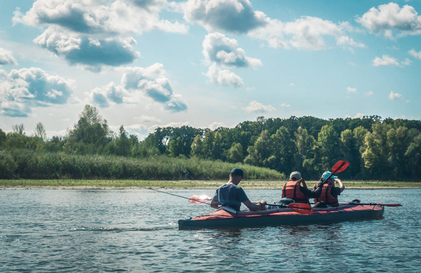 Kyiv / Ukraine - September 14 2019: Swimming on kayaks. Rear view of young people kayaking on lake together with beautiful nature in the backgrounds. - 写真・画像