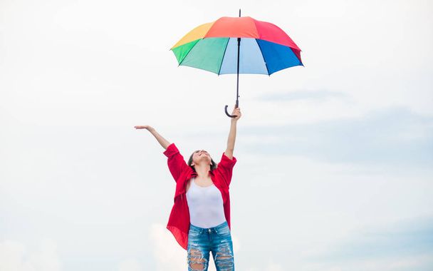 Welcoming fall. Pretty woman with colorful umbrella. Rainbow umbrella. Rainy weather. Good mood. Good vibes. Open minded person. Girl feeling good sky background. Easy and free. Good weather - Foto, Imagen