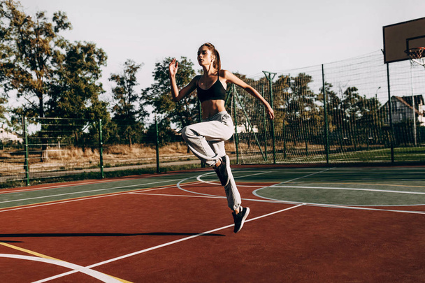 Attractive young girl sportswoman training outdoors, wearing hea - Valokuva, kuva