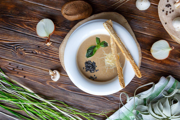 Kahverengi ahşap arka plan üzerinde champignons ve otlar ile makarna ile Mantar çorbası - Fotoğraf, Görsel