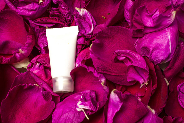 Cream tube on rose petals. - 写真・画像
