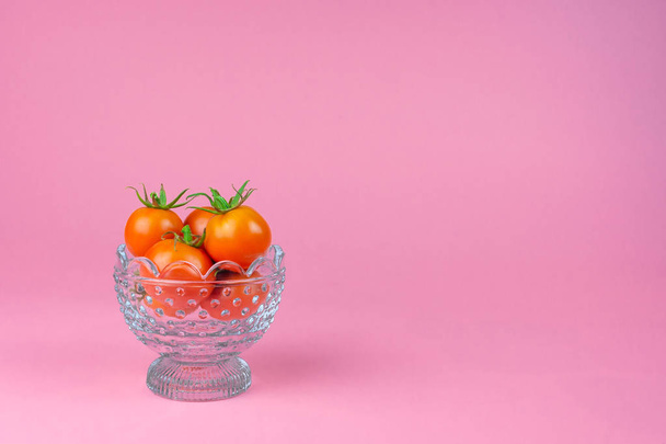Ντομάτες μέσα σε ένα γυάλινο βάζο σε ροζ φόντο - Φωτογραφία, εικόνα