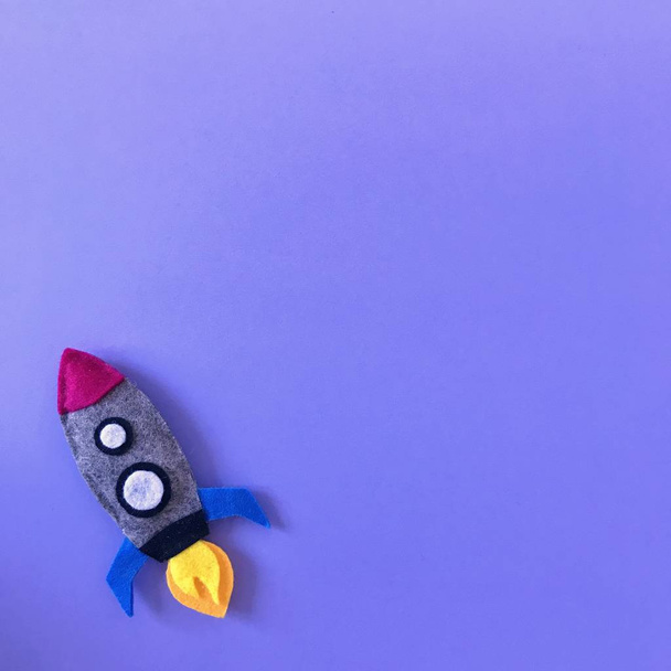 Purple Background with Handmade Felt Rocket Toy - Photo, image