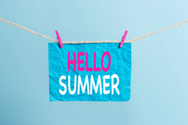 Writing note showing Hello Summer. Business photo showcasing Welcoming the warmest season of the year comes after spring Clothesline clothespin rectangle shaped paper reminder white wood desk. - Photo, Image