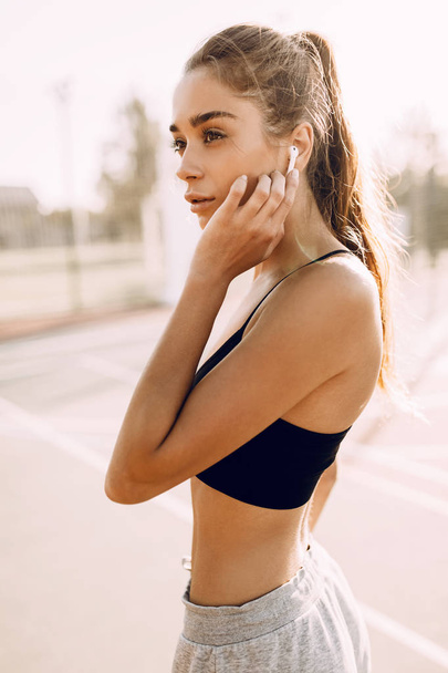 Imagem de mulher atlética atraente posando ao ar livre, durante a moda fitness, esporte
 - Foto, Imagem