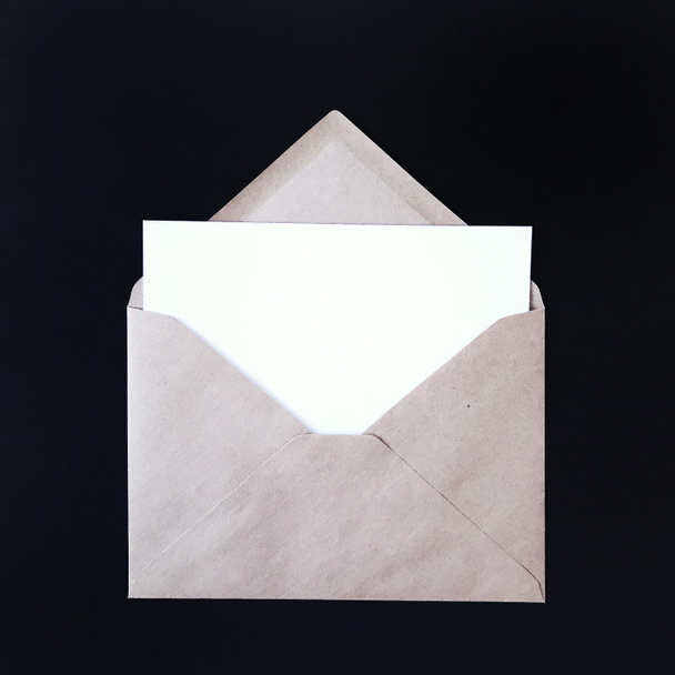Κενό λευκό ταχυδρομική κάρτα σε μαύρο φόντο mock up - Φωτογραφία, εικόνα