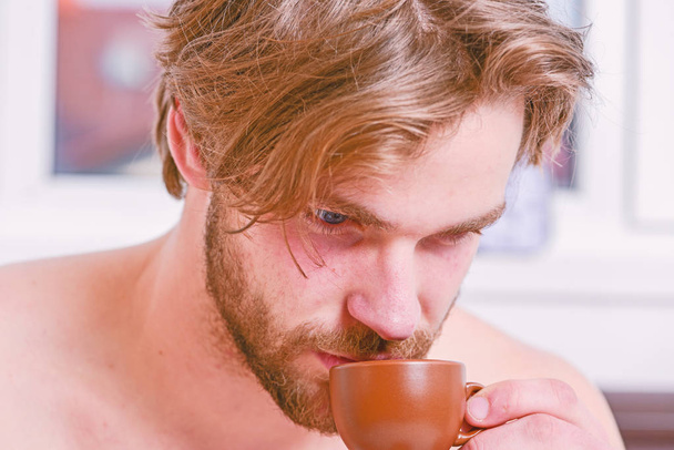 First sip. Every morning with his coffee. Man bearded handsome macho hold cup of coffee. Best time to have your cup of coffee. Guy attractive appearance man enjoy hot fresh brewed coffee close up - Foto, afbeelding