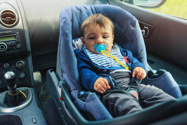 Babyschale für die Sicherheit. Junge sitzt im Auto im Sicherheitsstuhl.  - Foto, Bild