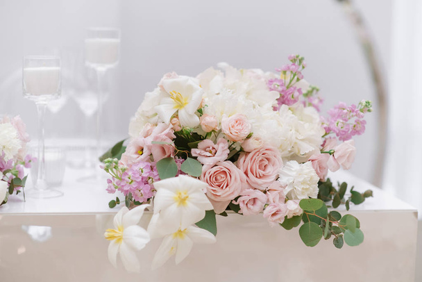 Elegantní malá Kytice růží, zelených a dalších barev na bílém svatebním stole - Fotografie, Obrázek