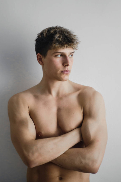 Muscled boy in front of white background - Foto, Imagen