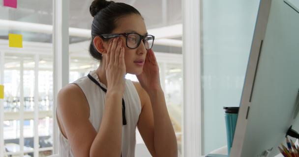 Portrét mladé vystresované smíšené rasy ženské podnikání tvůrčí práce v moderní kanceláři, pomocí počítače a sundání brýlí na čtení - Záběry, video
