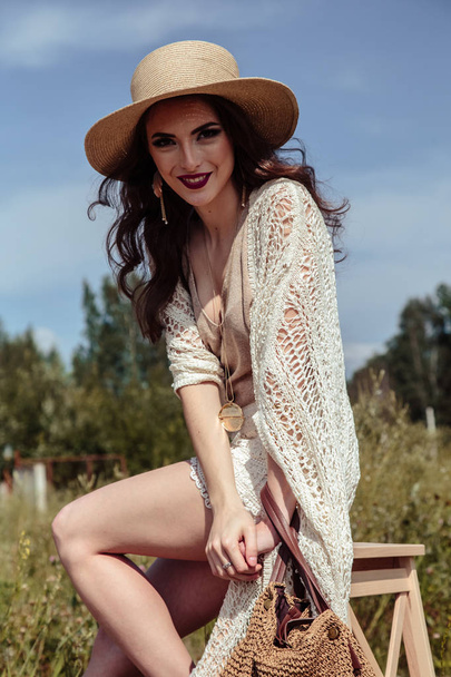 Beautiful brunette young woman in a stylish summer knit clothes posing outdoor. Fashion beauty portrait on nature - Photo, Image