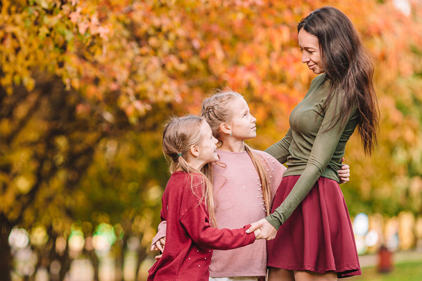 Little girl with mom outdoors in park at autumn day - Photo, Image