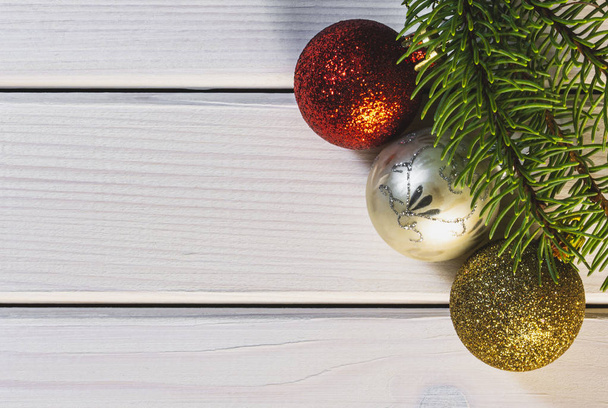 Decoraciones navideñas y rama de abeto sobre fondo de madera blanco, vista superior e imagen de espacio de copia
 - Foto, imagen
