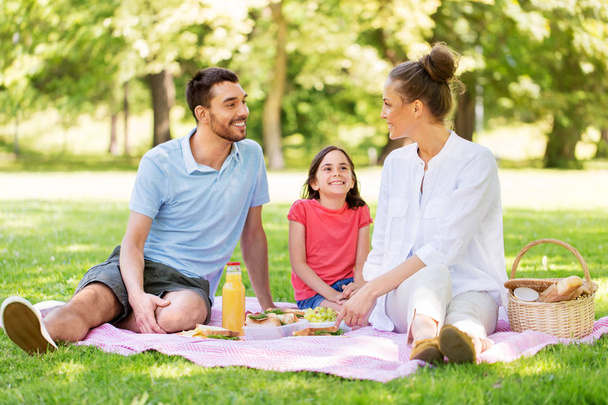 happy family having picnic at summer park - Фото, изображение