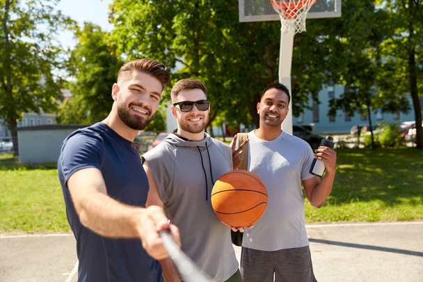 happy men taking selfie on basketball playground - Foto, afbeelding
