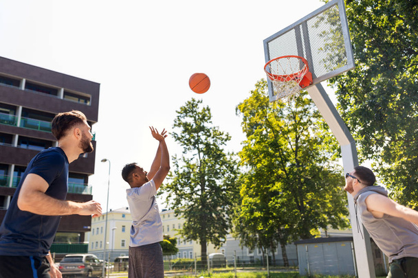 group of male friends playing street basketball - 写真・画像