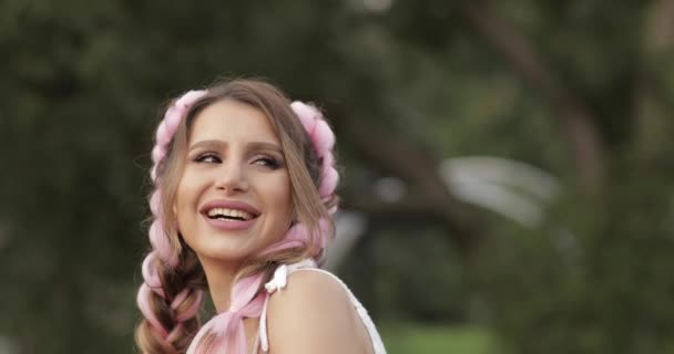Close-up viso bella spensierata giovane donna con acconciatura rosa rendendo aria bacio guardando la fotocamera
 - Filmati, video