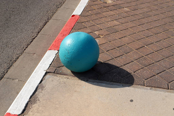 bolas de hormigón multicolor se encuentran en la acera de la ciudad y sirven como una barrera de la calzada
  - Foto, imagen