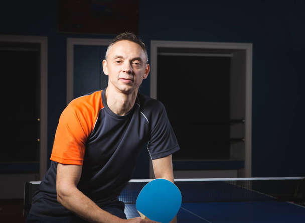 Portrait of sports man, male, athlete playing table tennis isolated on black background - Foto, immagini