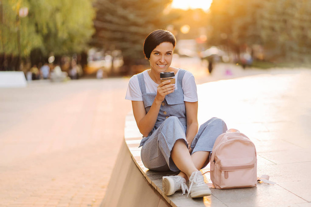 Young woman with reusable coffee cup at sunset. Sustainable lifestyle. Plastic free concept. - Fotó, kép