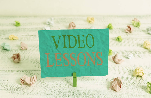 Sana kirjoittaa tekstiä Video Lessons. Business konsepti Online Koulutusmateriaali aihe Katselu ja oppiminen Vihreä clothespin valkoinen puu tausta värillinen paperi muistutus toimistotarvikkeita
. - Valokuva, kuva