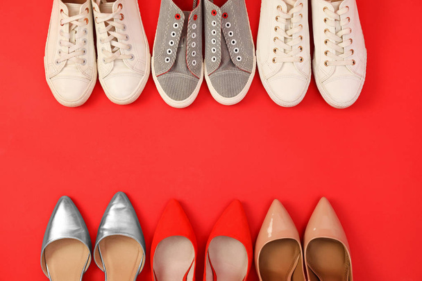 Flat lay composition with different bright shoes on red background. Space for text - Valokuva, kuva