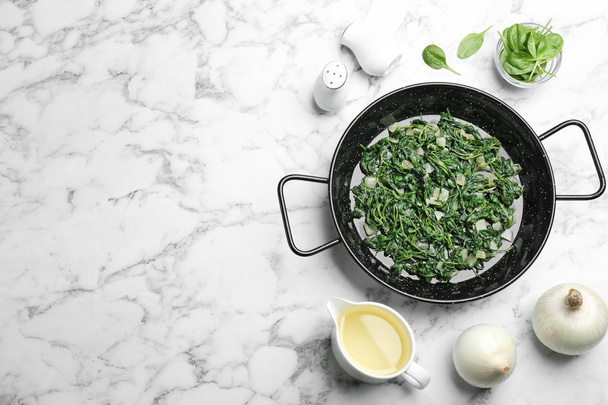 Flat lay composition with cooked spinach and space for text on white marble table. Healthy food - Foto, Imagen