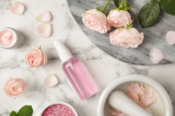 Flat lay composition with rose essential oil on marble table - Fotografie, Obrázek