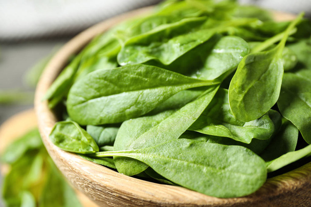 Fresh green healthy spinach in wooden bowl, closeup - Foto, afbeelding