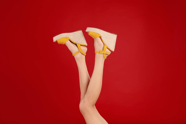 Woman in stylish shoes on red background - Fotó, kép