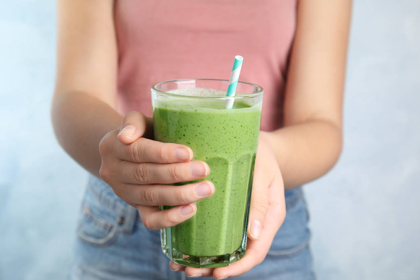 Young woman holding glass of tasty avocado smoothie with straw, closeup - Foto, Imagem