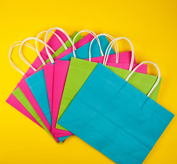 bolsas de compras de papel multicolor con asas blancas
  - Foto, imagen