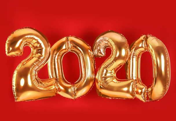 Golden balloons for party decoration on red background. 2020 New Year celebration - Foto, Imagen
