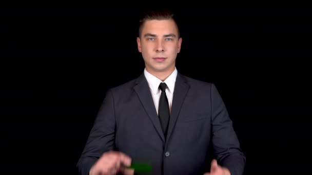 Joven hombre de negocios presenta una tarjeta verde de banco y muestra como con su mano. Tarjeta verde Chromakey. Hombre con traje negro
 - Imágenes, Vídeo