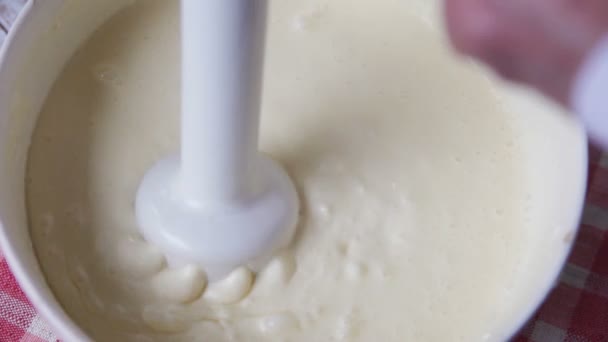 A woman uses an immersion blender to combine a cream cheese mixture - Кадри, відео