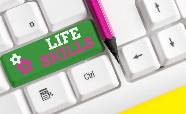 Conceptual hand writing showing Life Skills. Business photo showcasing that is necessary or desirable full participation in everyday White pc keyboard with note paper above the white background. - Photo, Image